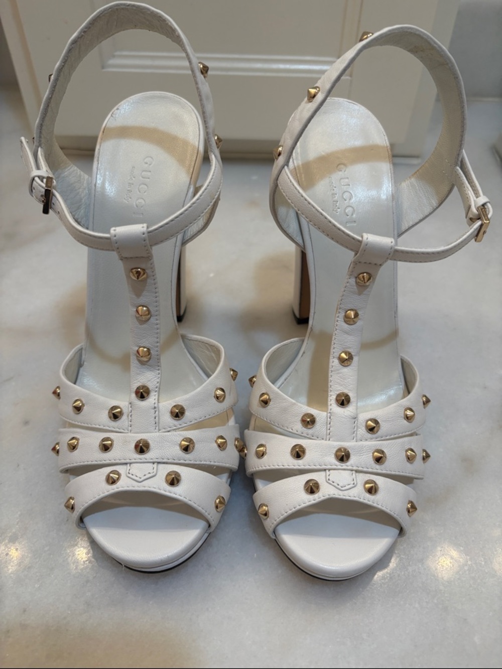 Gucci White Leather Studded T-Strap Sandals with Gold Accents.